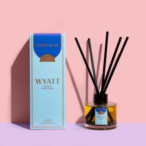 Wyatt diffuser with packaging on a pink and purple gradient background
